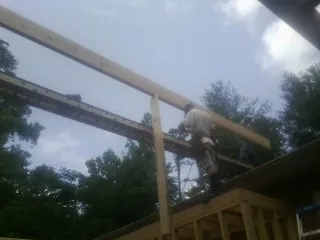 Carpenter setting a ridge beam over a new addition frame — Ice Dam Removal by Roofing Brothers in Giltner