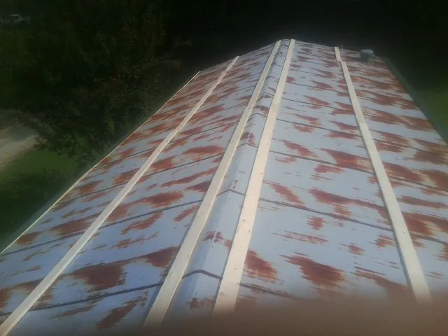 Rusted metal roof panels with new wood purlins before replacement — Storm Damage Roof Repair in Giltner by Roofing Brothers